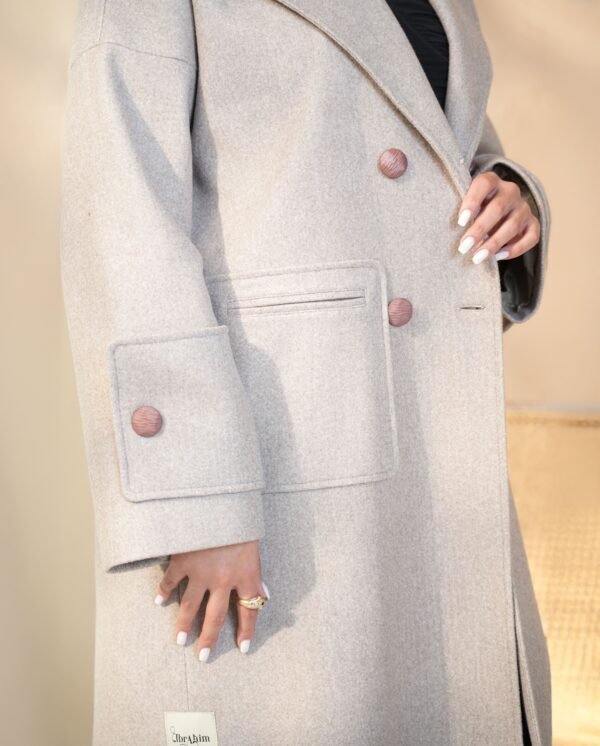 grace-beige-mantle-front-view – A woman modeling the beige mantle coat with oversized sleeves