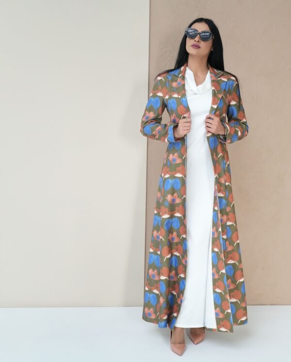 blossom-bloom-mantle-front-view – A woman modeling a vibrant floral-patterned mantle coat.