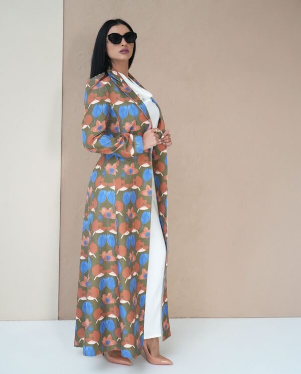 blossom-bloom-mantle-front-view – A woman modeling a vibrant floral-patterned mantle coat.