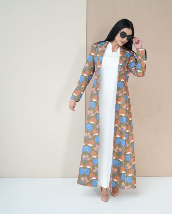 blossom-bloom-mantle-front-view – A woman modeling a vibrant floral-patterned mantle coat.