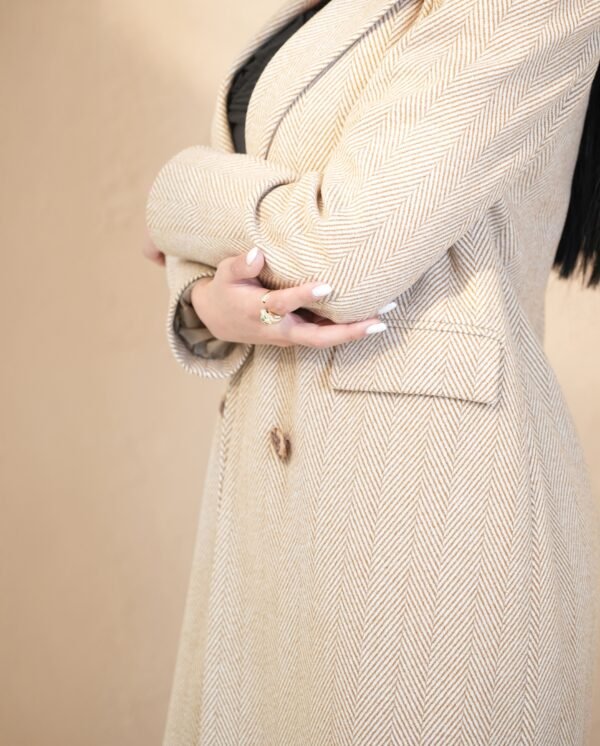 classic-sand-mantle-front-view – Woman modeling a sand beige mantle coat with double-breasted buttons.