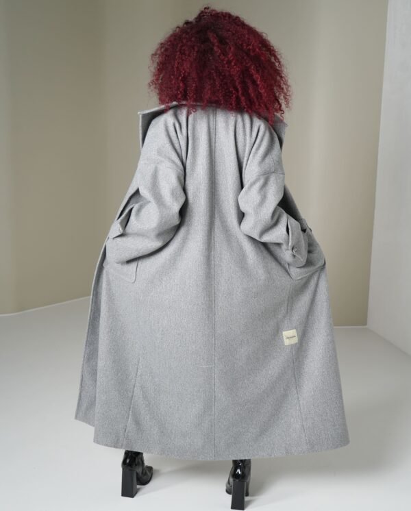 light-grey-mantle-styled-look – Styled light grey coat paired with a purple top and black boots for a modern finish.