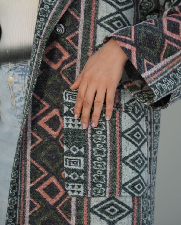 ethnic-geometric-mantle-full-view – Woman modeling a geometric-patterned mantle coat with relaxed styling.